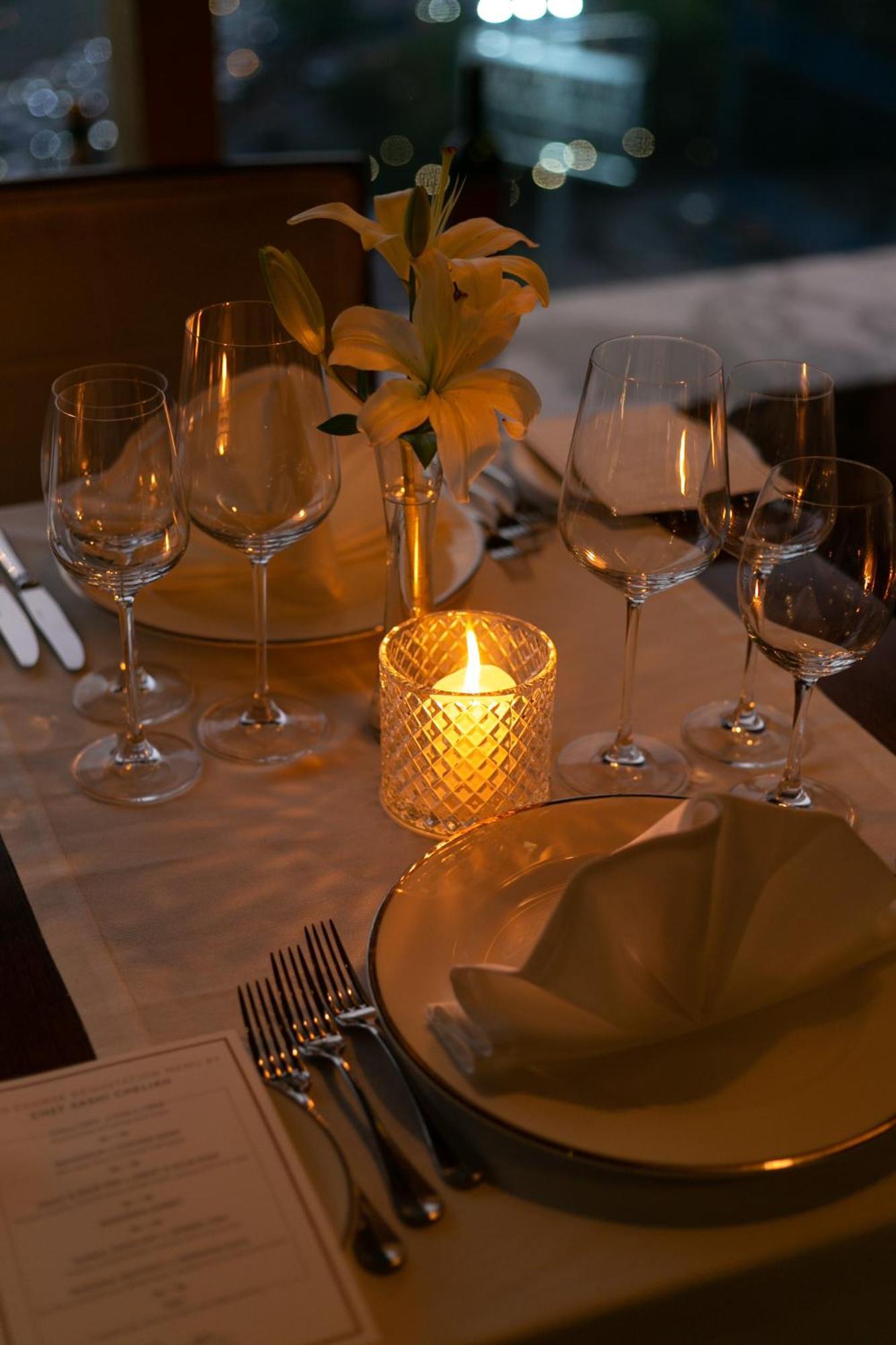 The Leela Ambience Gurugram Hotel & Residences - The Luxury Urban Sanctuary Gurgaon Dış mekan fotoğraf A candle on a dinner table